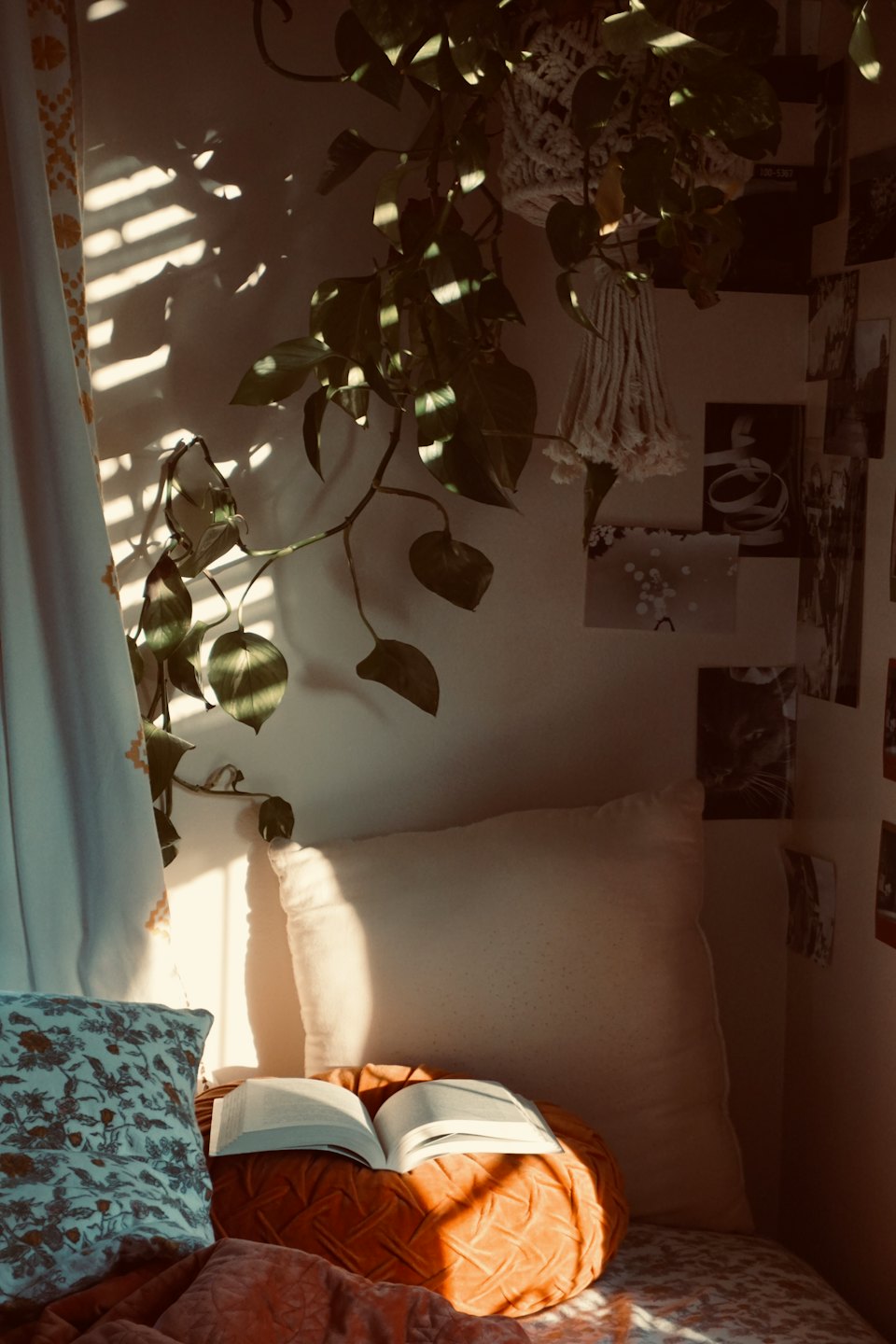 An open book rests on a cushion in a cozy reading nook.